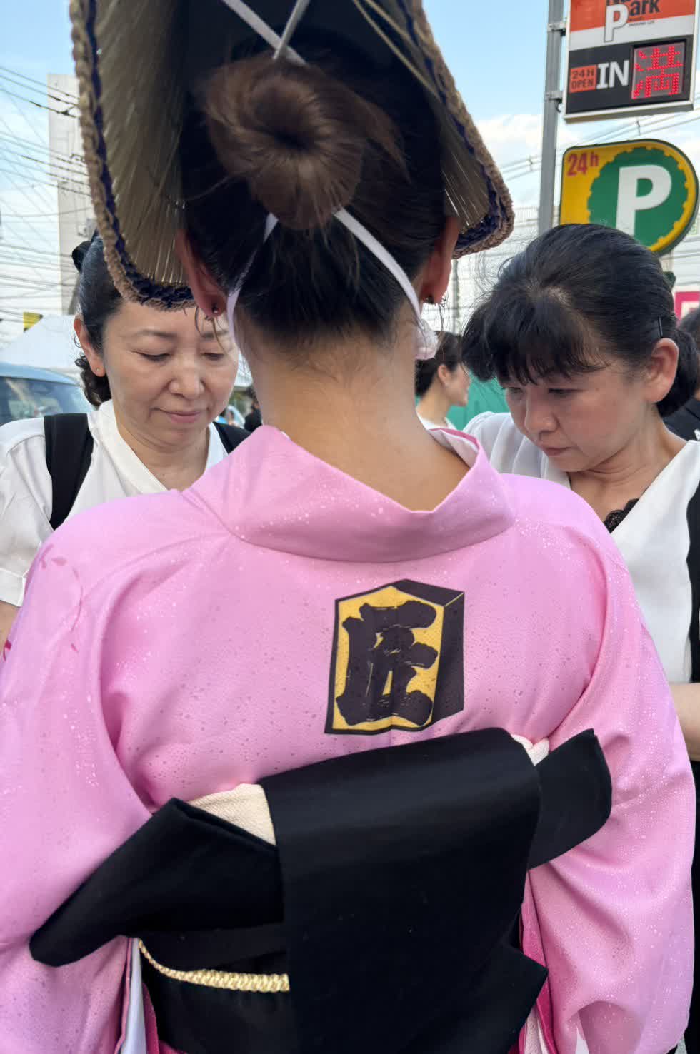 現場で、着付け師が着姿を細かく直す